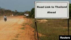 FILE - A sign showing the road leading to Thailand is seen near Dawei in southern Myanmar, close to the site of a planned special economic zone and deep sea port, Nov. 19, 2011.