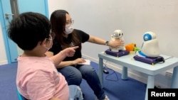 Sarah Ng, seorang tutor, menggunakan robot untuk mengajar anak berkebutuhan khusus cara memperkenalkan diri, di Hong Kong, China, 17 April 2021. (Foto: Yoyo Chow/Reuters)