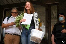 FILE - Russian journalist Svetlana Prokopyeva smiles while holding flowers after a court session in Pskov, Russia, July 6, 2020. A court in Pskov convicted Prokopyeva on charges of condoning terrorism.