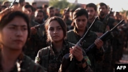 FILE - Fighters from the Syrian Democratic Forces attend the funeral a fellow fighter killed in the town of Hajin during battles against the Islamic State group, in the Kurdish-controlled city of Qamishly in northeastern Syria, Dec. 3, 2018. 