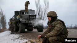 FILE - Ukrainian servicemen, pushed by pro-Russia rebels out of Debaltseve, are seen at new positions near Artemivsk, Donetsk region, Ukraine, Feb. 19, 2015. 