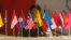 FILE - A woman sits in front of flags of the Association of South East Asian Nations (ASEAN).
