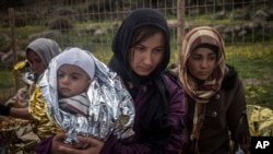 یونان پہنچنے والی پناہ گزین عورتیں بچے سڑک پر کھڑے ہیں۔ (فائل فوٹو)