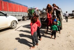 Syrian Arab and Kurdish civilians arrive to Tall Tamr town, in the Syrian northwestern Hasakeh province, after fleeing Turkish bombardment on the northeastern towns along the Turkish border, Oct. 10, 2019.