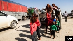 Syrian Arab and Kurdish civilians arrive to Tall Tamr town, in the Syrian northwestern Hasakeh province, after fleeing Turkish bombardment on the northeastern towns along the Turkish border, Oct. 10, 2019.