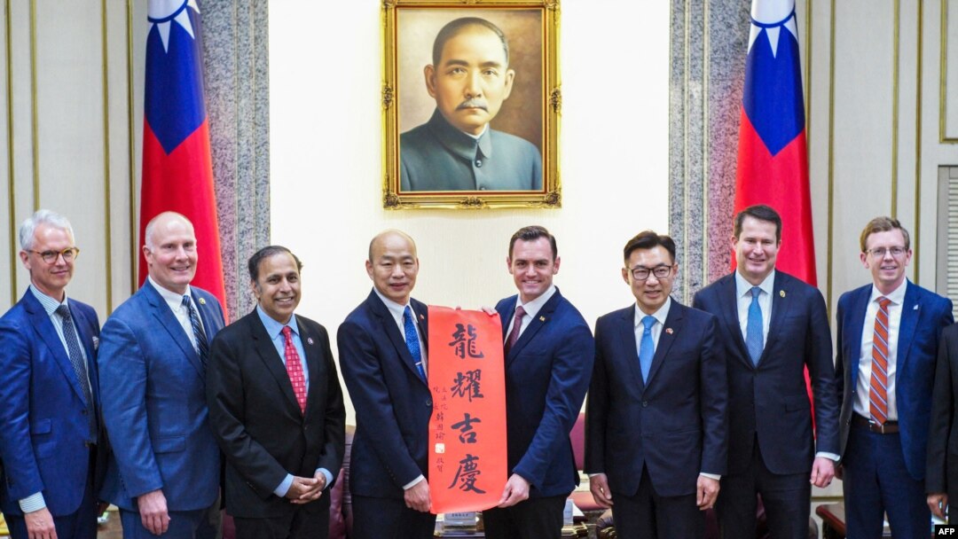 Anggota DPR AS Mike Gallagher (ke-4 dari kanan) menerima Chunlian, hiasan beraksara China yang bertuliskan "Semoga Anda beruntung", dari Ketua Parlemen Taiwan Han Kuo-yu (ke-4 dari kiri), oposisi utama Kuomintang (KMT ), di Parlemen di Taipei, 22 Februari 2024. (Foto: AFP)
​