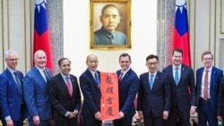 Anggota DPR AS Mike Gallagher (ke-4 dari kanan) menerima Chunlian, hiasan beraksara China yang bertuliskan "Semoga Anda beruntung", dari Ketua Parlemen Taiwan Han Kuo-yu (ke-4 dari kiri), oposisi utama Kuomintang (KMT ), di Parlemen di Taipei, 22 Februari 2024. (Foto: AFP)
​