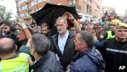 Spain's King Felipe VI is protected after a crowd of angry survivors of Spain's floods have tossed mud and shouted insults at the King and government officials when they made their first visit to one of the hardest hit towns after floods in Paiporta near Valencia, Nov. 3, 2024. 