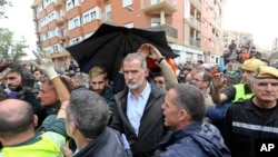 Raja Spanyol Felipe VI saat berkunjung ke wilayah Paiporta di dekat Valencia, yang terdampak parah oleh banjir, pada 3 November 2024. (Foto: AP/Hugo Torres)