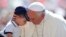 El Papa abraza a un niño al llegar a la Plaza de San Pedro el miércoles 19 de junio para su audiencia semanal.