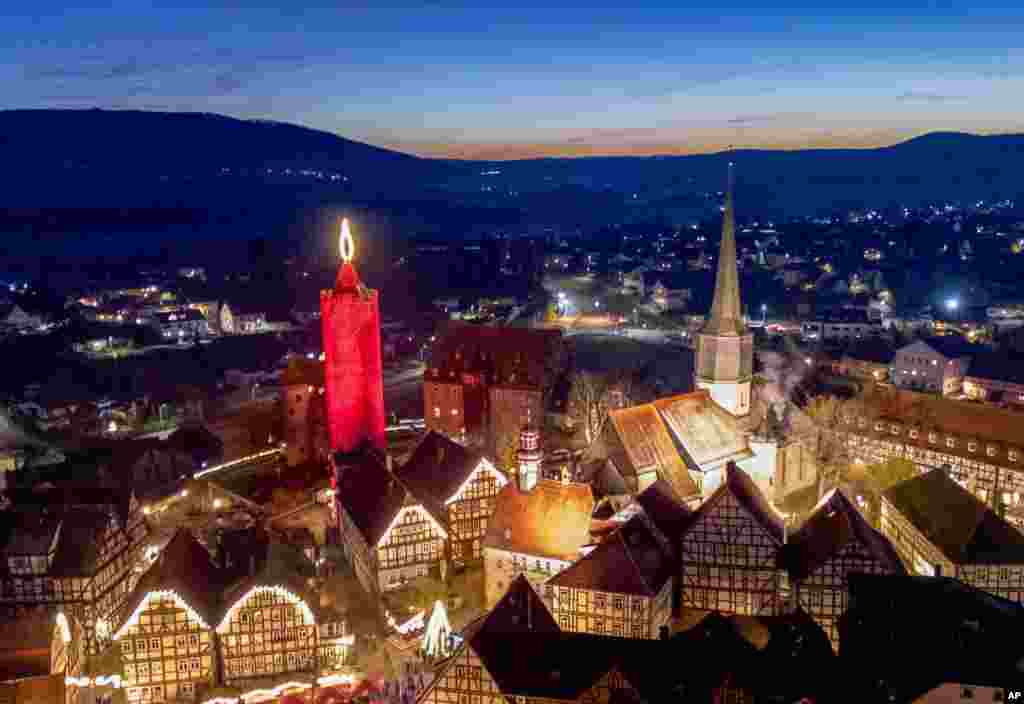 A 42-meter-high candle which is an illuminated medieval tower shines in the historic city center of Schlitz, Germany, Nov. 30, 2024.