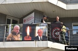 A view shows a banner with portraits of Russian mercenary chief Yevgeny Prigozhin and Wagner group commander Dmitry Utkin at a makeshift memorial outside the local office of the Wagner private mercenary group in Novosibirsk, Russia August 24, 2023. (REUTERS/Stringer)