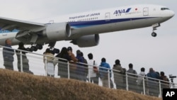 People enjoy watching a Japanese carrier All Nippon Airways' plane landing at the Narita International Airport from a popular viewing spot at Sakuranoyama Park in Narita, east of Tokyo, Saturday, March 14, 2015. (AP Photo/Koji Sasahara)