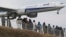 People enjoy watching a Japanese carrier All Nippon Airways' plane landing at the Narita International Airport from a popular viewing spot at Sakuranoyama Park in Narita, east of Tokyo, March 14, 2015.
