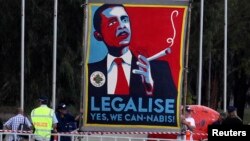 FILE - Marijuana activists use a sign to call on President Barack Obama to make the drug legal.