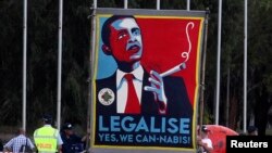 FILE - Marijuana activists use a sign to call on President Barack Obama to make the drug legal, Nov. 16, 2011.