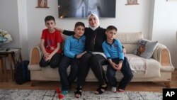 Fatima Alzahra Shon, 32, a Syrian refugee, poses with her children in their apartment in Istanbul, Turkey, Sept. 17, 2021. 