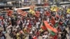 Des partisans de l'Union nationale pour l'indépendance totale de l'Angola (UNITA) et d'autres groupes d'opposition brandissent des bannières et des drapeaux lors d'une marche de protestation contre le parti au pouvoir en Angola. Luanda, 23 novembre 2024. AFP / Julio Pacheco Ntela