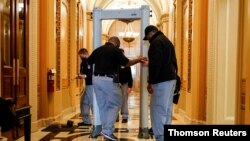 Security personnel set up a metal detector in front of an entrance to the House Chamber, on Capitol Hill in Washington, January 12, 2021.