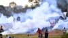 Les gens fuient les gaz lacrymogènes alors que la pop star ougandaise et candidat à la présidentielle Robert Kyagulanyi, alias Bobi Wine, fait campagne près de Kampala, en Ouganda, le 30 novembre 2020. REUTERS / Abubaker Lubowa /