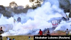 Les gens fuient les gaz lacrymogènes alors que la pop star ougandaise et candidat à la présidentielle Robert Kyagulanyi, alias Bobi Wine, fait campagne près de Kampala, en Ouganda, le 30 novembre 2020. REUTERS / Abubaker Lubowa /