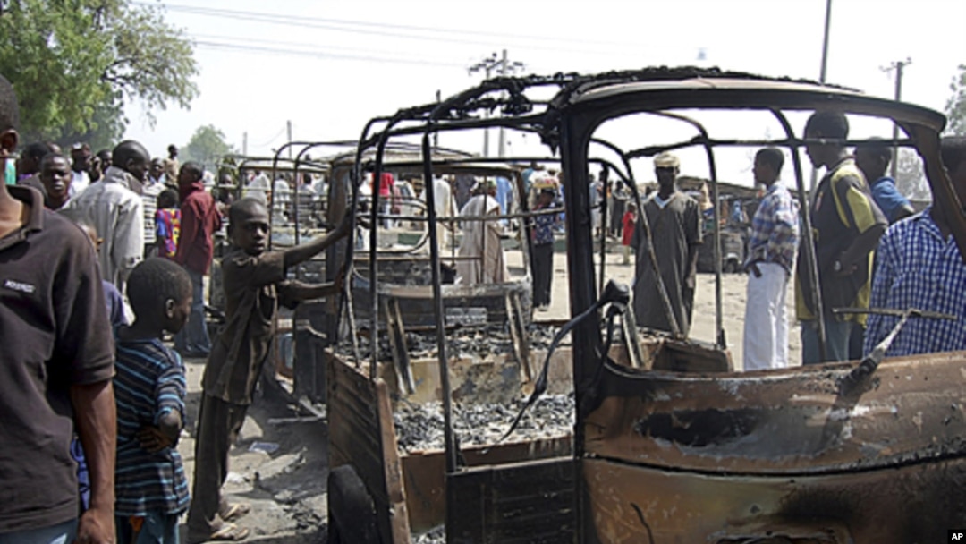 Residents survey vehicles damaged after a bomb blast at a primary school in Maiduguri, the capital of Nigeria's Borno state, February 29, 2012. 