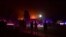 People watch as the Bobcat Fire burns on hillsides behind homes in Arcadia, California on September 13, 2020 prompting mandatory evacuations for residents of several communitu - California wildfires have shrouded much of the western United States in…