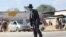 FILE - An elderly man, wearing a mask to protect against COVID-19, walks at a rural shopping center in Zvimba, Zimbabwe, June 25, 2021. 