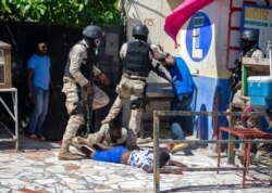 Police officers detain demonstrators during a protest to demand the resignation of Haitian President Jovenel Moise in Port-au-Prince, Haiti, Feb. 7, 2021.