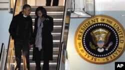 President Barack Obama and first lady Michelle Obama walk off Air Force One after arriving at O'Hare International Airport in Chicago, November 6, 2012. 