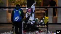 Un fanático se encuentra frente a un monumento improvisado afuera del hotel donde el excantante de One Direction, Liam Payne, fue encontrado muerto después de caer desde un balcón en Buenos Aires, Argentina, la mañana después de su muerte el jueves 17 de octubre de 2024. 