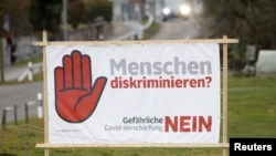 A poster reading: "Discrimination against people? No to COVID restriction tightening" is seen before Swiss voters decide about the federal government's pandemic response plan in a binding referendum, near Oberwil-Lieli in Switzerland, Nov.16, 2021. 