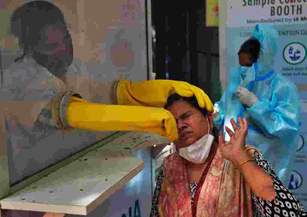A health worker collects a nasal swab sample to test for COVID-19 in Hyderabad, India.