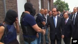 Presiden Perancis Francois Hollande bersalaman dengan anggota kepolisian di TKP serangan teroris di gereja di Normandy, Selasa (26/7).