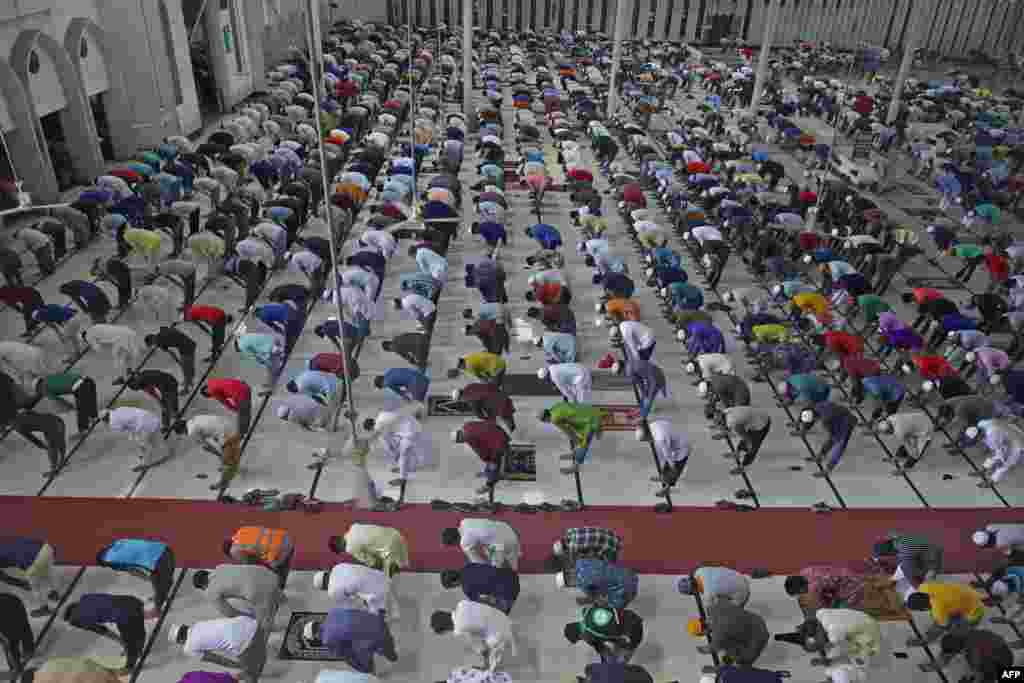 بنگلہ دیش کے دارالحکومت ڈھاکہ میں کرونا وائرس کے باعث عائد پابندیوں کے دوران لوگوں نے سماجی فاصلے کا خیال رکھتے ہوئے نماز ادا کی۔