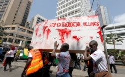 FILE - Members of the civil society carry a coffin stained with mock blood as they chant slogans during a protest dubbed 'Stop extrajudicial killings', in Nairobi, Kenya.
