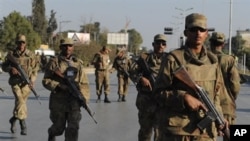 Pakistani soldiers take up position outside a besieged mosque in Pakistan's garrison city Rawalpindi, 04 Dec 2009