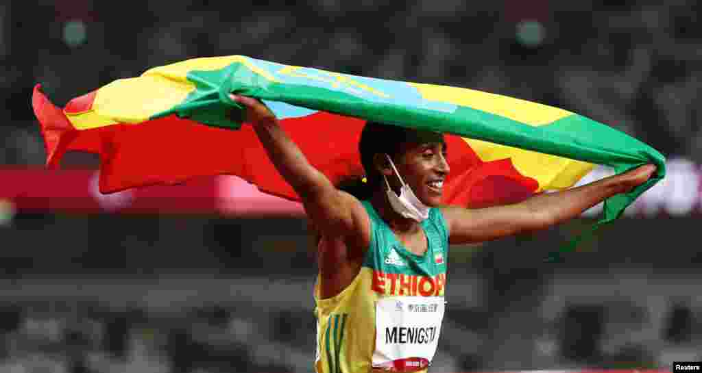 Gold Medallist Tigist Gezahagn Menigstu of Ethiopia celebrates with the flag of Ethiopia REUTERS/Lisi Niesner