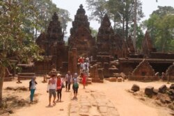 In this April 15, 2016, photo, tourists visit the Banteay Srey temple of the Angkor complex.