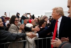 President Donald Trump greets supporters on arriving at the Louis Armstrong New Orleans International Airport, in Kenner, La.