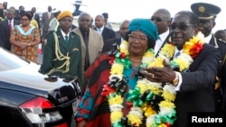 Zimbabwe's President Robert Mugabe, right, welcomes Malawian counterpart Joyce Banda upon her arrival at Harare International Airport, April 23, 2013.