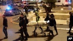 Israeli police men and paramedics carry the body of a man shot near Damascus Gate in the Old City of Jerusalem, Dec. 4, 2021.