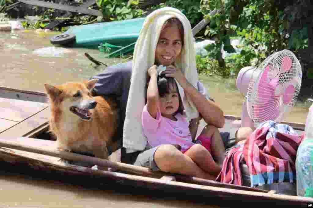 A family evacuates their flooded neighborhood by boat, Ayutthaya, October 6, 2011. (VOA - D. Schearf)