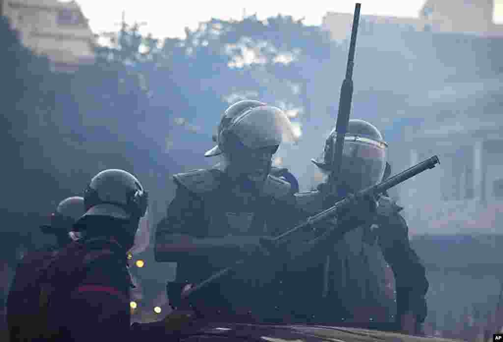 A Senegalese riot policeman loads rubber bullets into his weapon in Dakar, February 21, 2012. (Reuters)