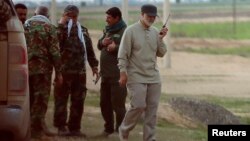 Iranian Major General Qassem Soleimani uses a walkie-talkie at the front line during offensive operations against Islamic State militants in the town of Tal Ksaiba in Salahuddin province, Iraq, March 8, 2015. 