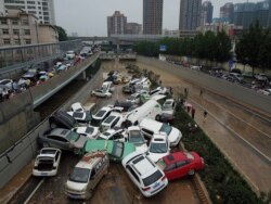 FILE - An aerial view shows cars sitting in floodwaters at the entrance of a tunnel after heavy rains hit the city of Zhengzhou in China's central Henan province.