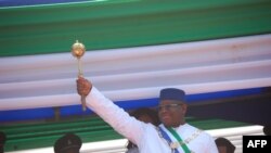 Le président de la Sierra Leone, Maada Bio, soulève le sceptre du pouvoir lors de son investiture à Freetown le 12 mai 2018.