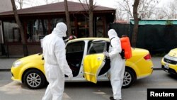Municipality workers wearing protective suits sanitise a taxi in Karaagac district against the coronavirus disease (COVID-19) near Turkey's Pazarkule border crossing with Greece's Kastanies, in Edirne, Turkey, March 10, 2020. 