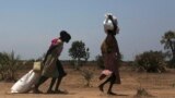 FILE - Women carry food at a food distribution site in Nyal, Unity State. More than one million people have been forced from their homes by the conflict, of which 803,200 have been displaced within South Sudan and 254,600 have fled to neighbouring countr