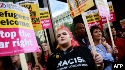 People hold anti-racism placards as they take part in a demonstration outside the headquarters of the Reform U.K. political party in London on Aug. 10, 2024.